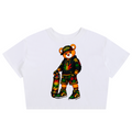 A white short-sleeve crop top featuring a colorful cartoon teddy bear graphic wearing a Rasta-themed outfit and holding a skateboard, displayed on a clean white background.