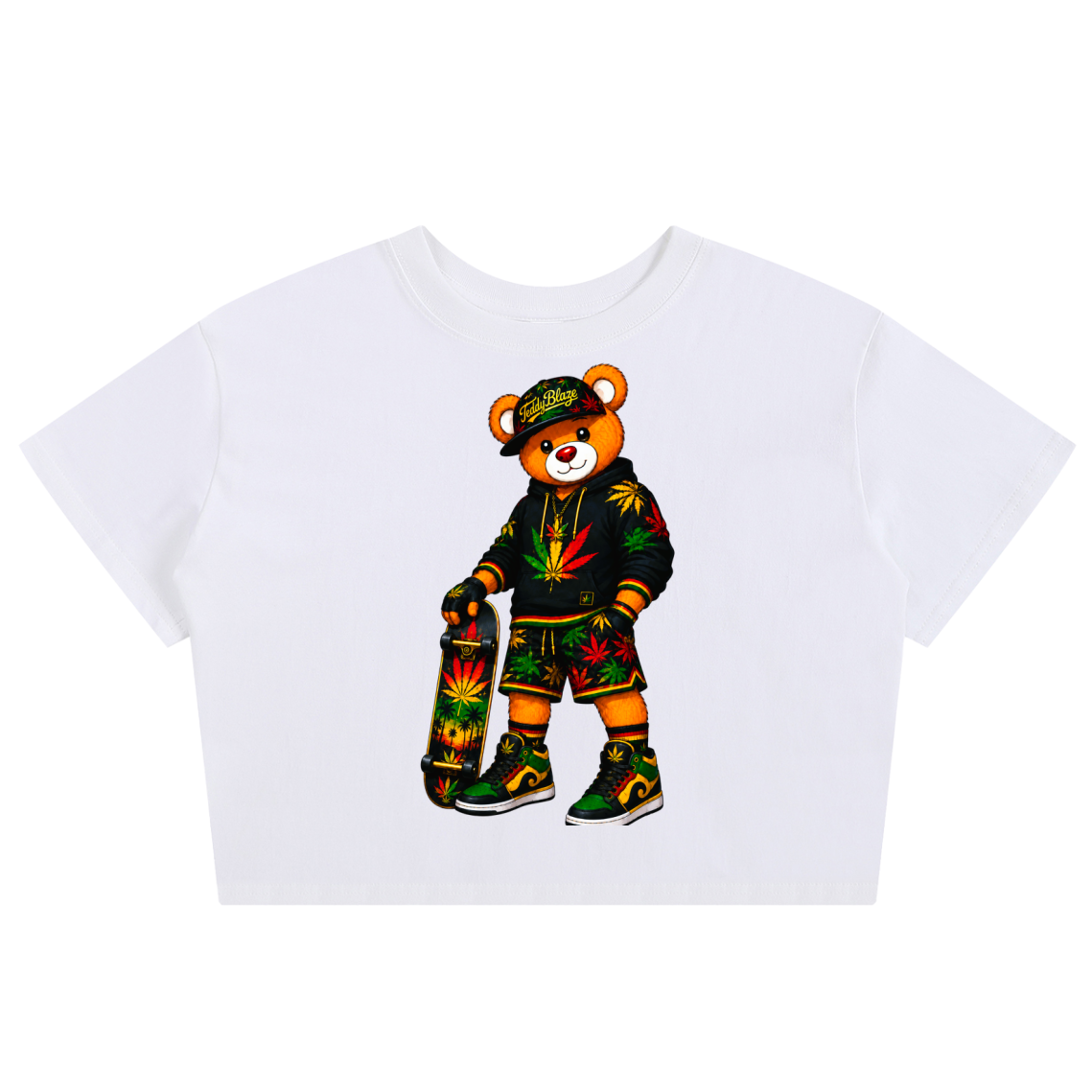 A white short-sleeve crop top featuring a colorful cartoon teddy bear graphic wearing a Rasta-themed outfit and holding a skateboard, displayed on a clean white background.