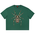 A dark green short-sleeve t-shirt featuring a large, detailed spider graphic on the front. The spider is decorated with a crown and made of intricate patterns of gold, brown, black, and white.