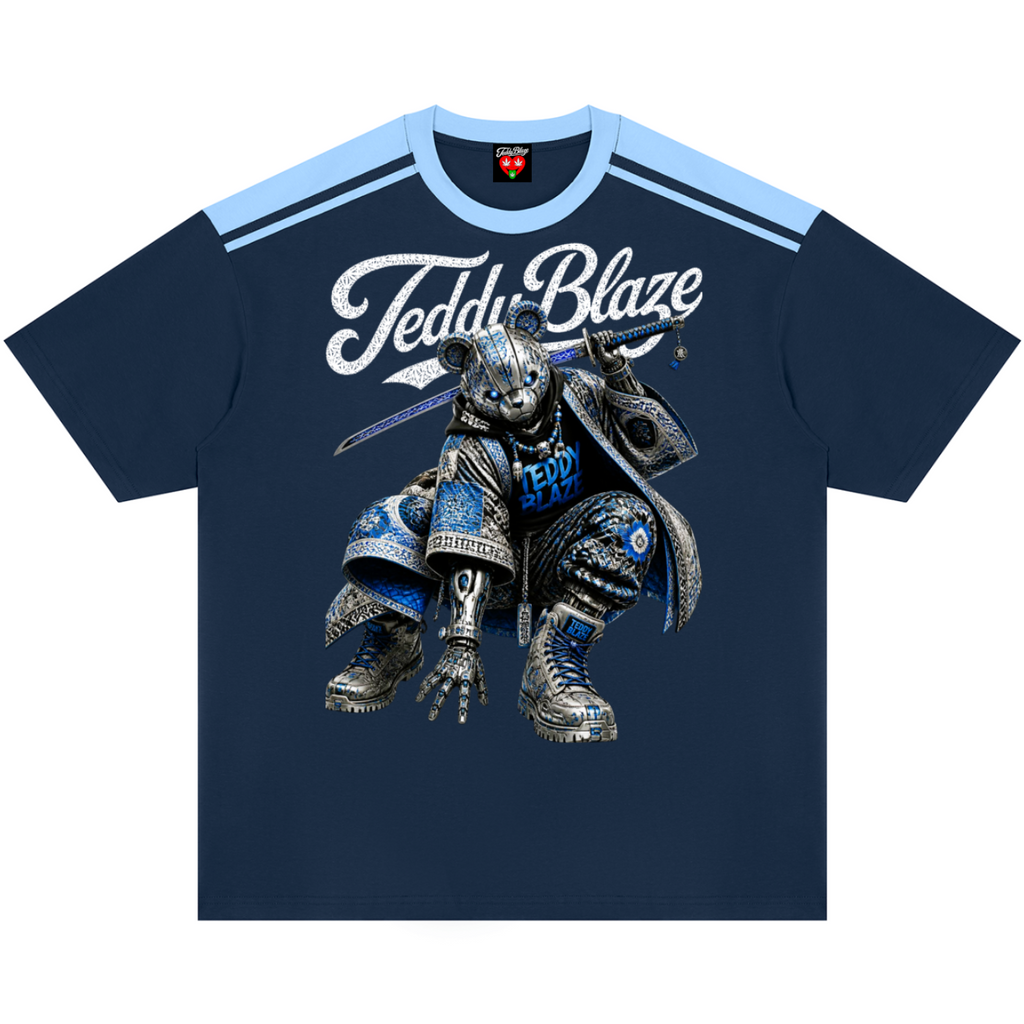 A navy blue short-sleeve t-shirt with a light blue shoulder stripe pattern and a large graphic of a robotic teddy bear wearing armor. The text 'Teddy Blaze' is printed in white across the chest.