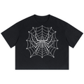 A black short-sleeve crop top t-shirt featuring a white spiderweb and spider graphic printed on the front, displayed against a solid white background.