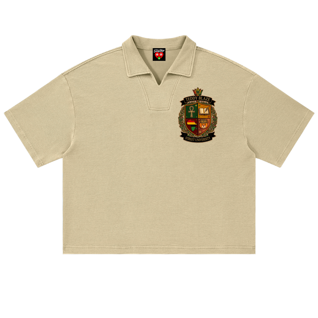 A beige short-sleeve polo shirt with a textured knit fabric, featuring a detailed embroidered crest on the left chest and a red neck label.