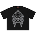 A black short-sleeve crewneck t-shirt featuring a large white and gray graphic print on the front. The graphic is an ornate crest with an iron cross and the text 'THE WAY OF THE SINNER', 'EST TEDDY BLAZE', and '2020'.