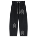 Black drawstring sweatpants with three white embroidered tribal-style logos, one on the right thigh and two on the lower legs, shown flat on a white background.