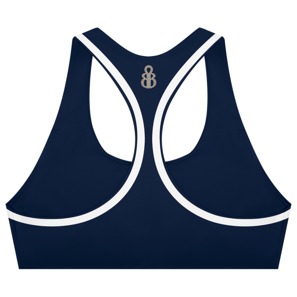 A navy blue sports bra with white contrast trim and a small metallic monogram logo at the center back of the neckline, shown on a plain white background.