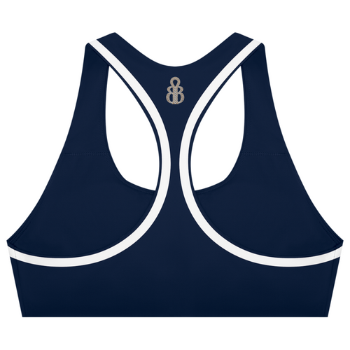 A navy blue sports bra with white contrast trim and a small metallic monogram logo at the center back of the neckline, shown on a plain white background.