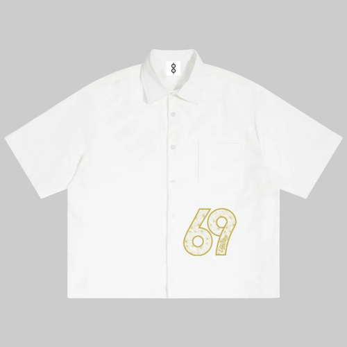 A white short-sleeve button-up shirt with a small yellow graphic print of the number 69 on the lower right front, displayed flat against a white background.