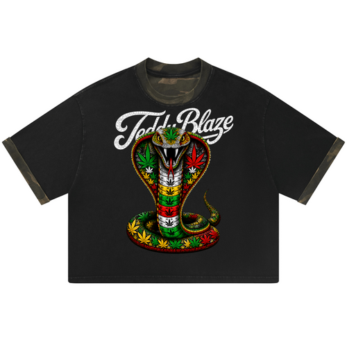 A black ringer t-shirt featuring a large graphic of a hooded snake with green, red, and yellow stripes, adorned with cannabis leaves, and the text 'Teddy Blaze' in white script above it.