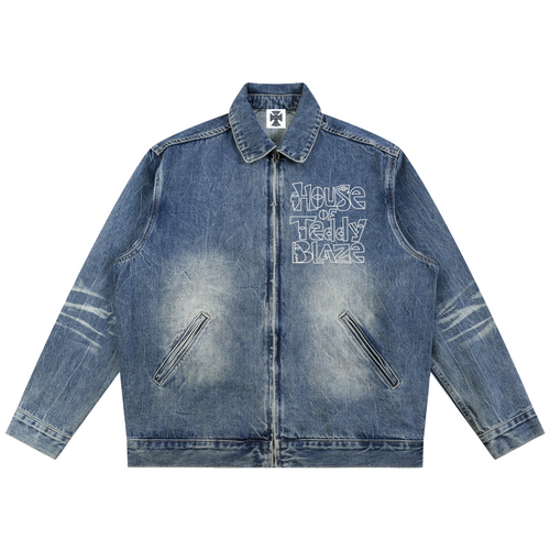 A blue denim jacket with a distressed wash, featuring 'House of Teddy Blaze' text printed on the left chest and zippered pockets, shown against a plain white background.