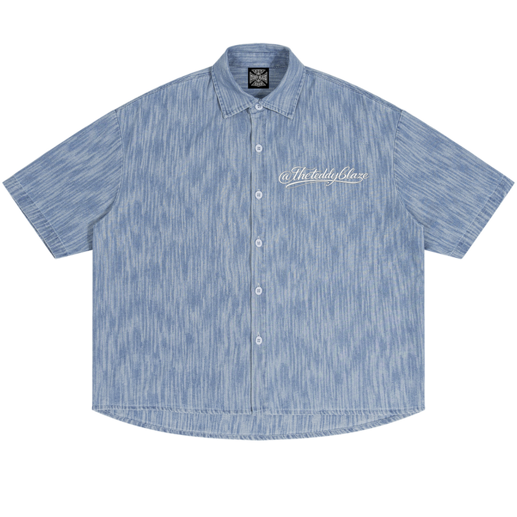 Shop the Signature Boxy Vintage Wash Denim Camp Shirt by Teddy Blaze. Lightweight 230 GSM blue striated denim short sleeve button-up from THE BLAZE MAN.