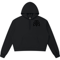 Shop the Signature Cachet Boxy Raw Edge V-Neck Hooded Jumper by Teddy Blaze. 360 GSM black heavy fleece hoodie with slit V-neck and Cachet emblem from The Mature Mocha Collection.