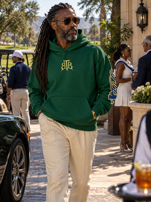Shop the Signature Cachet On the Greens Fleece Hooded Jumper by Teddy Blaze. Forest green 190g/m² fleece pullover featuring gold TB chest and sleeve graphics.