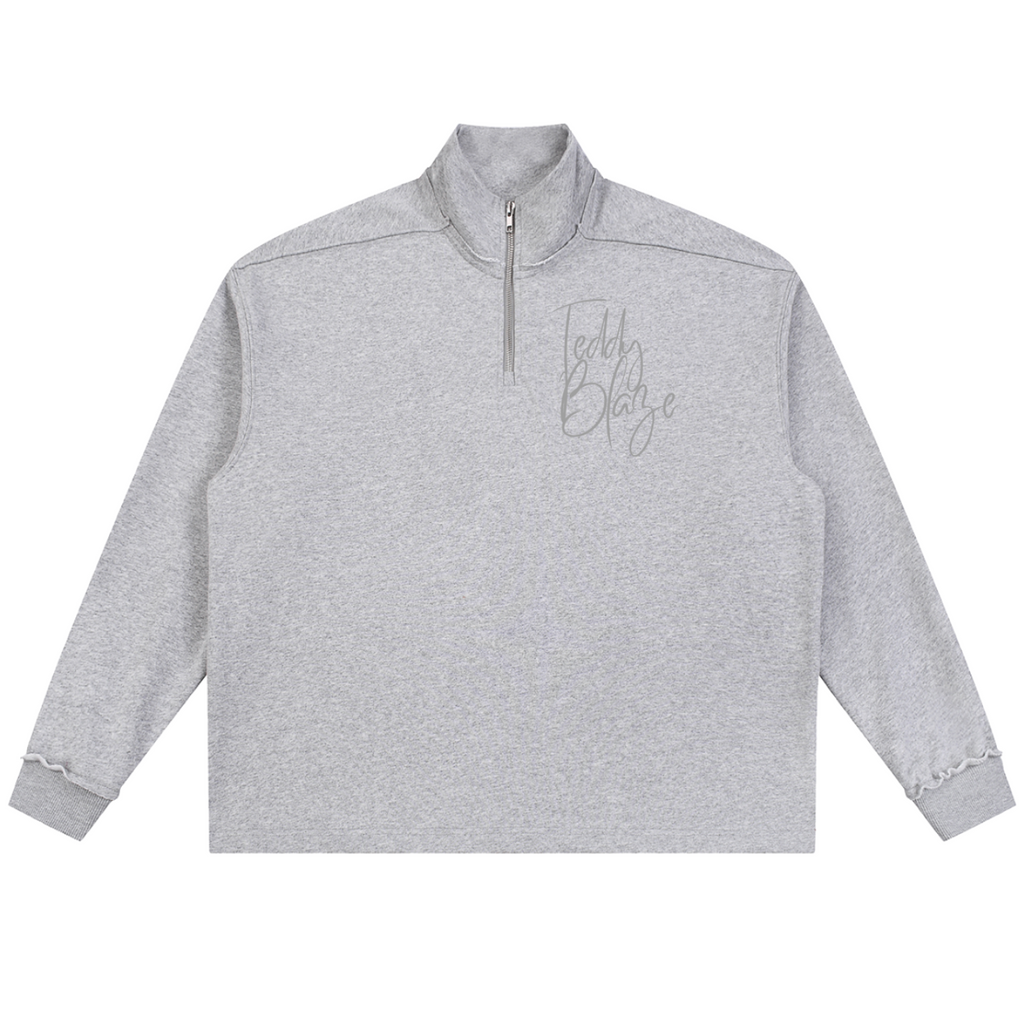 Elevate your cool-weather layering with the House of Teddy Blaze Signature Rolled Edge Fleece Quarter Zip. Heather gray 450 gsm fleece, stand collar, rolled edge seams, and script logo embroidery. Shop NYC to Vegas style.