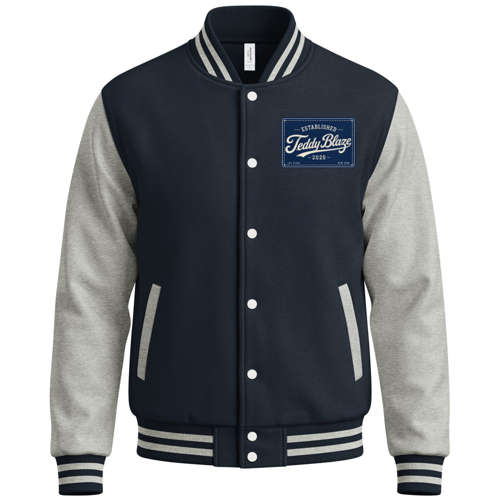 Shop the Men's Signature Varsity Jacket by Teddy Blaze. Medium-heavy fleece jacket with contrast sleeves, snap closure, and script Teddy Blaze back graphic.