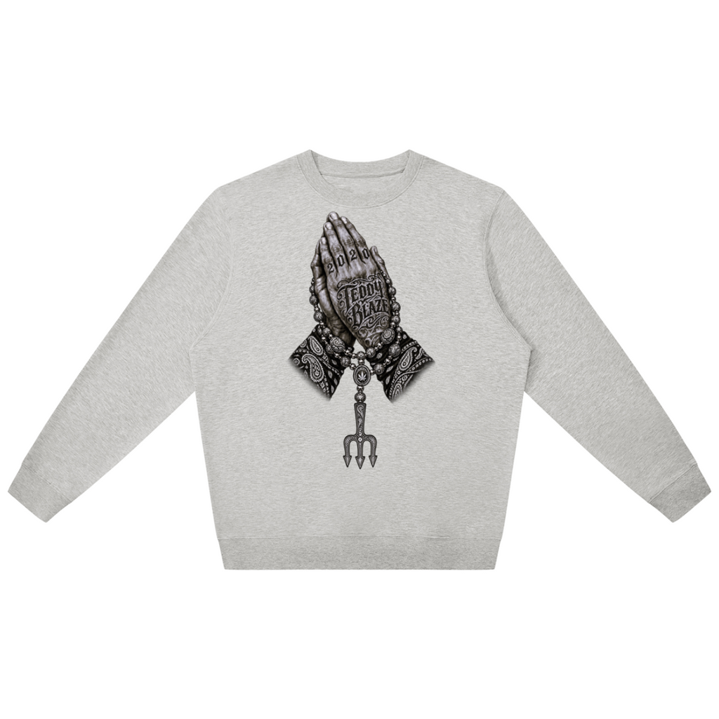 Elevate your cool-weather layers with the Teddy Blaze Sin City Sacred Jumper. Heather gray cotton-blend crewneck with tattoo praying hands and Sin City back print. Shop NYC to Vegas style.
