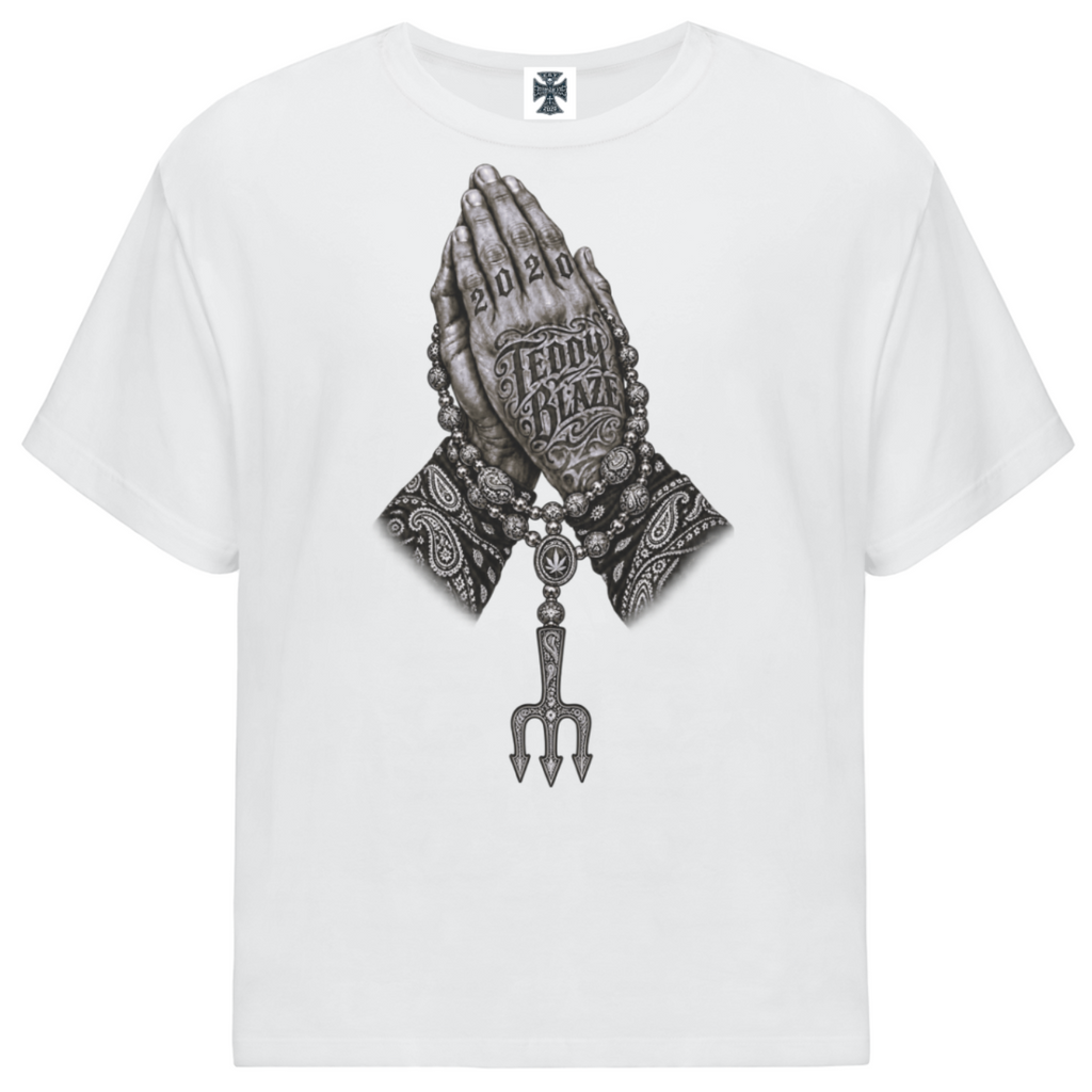 Elevate your casualwear with the Teddy Blaze Sin City Sacred Oversized Tee. Black stretch-cotton, tattoo praying hands print, and ornate back graphic. Shop NYC to Vegas style.