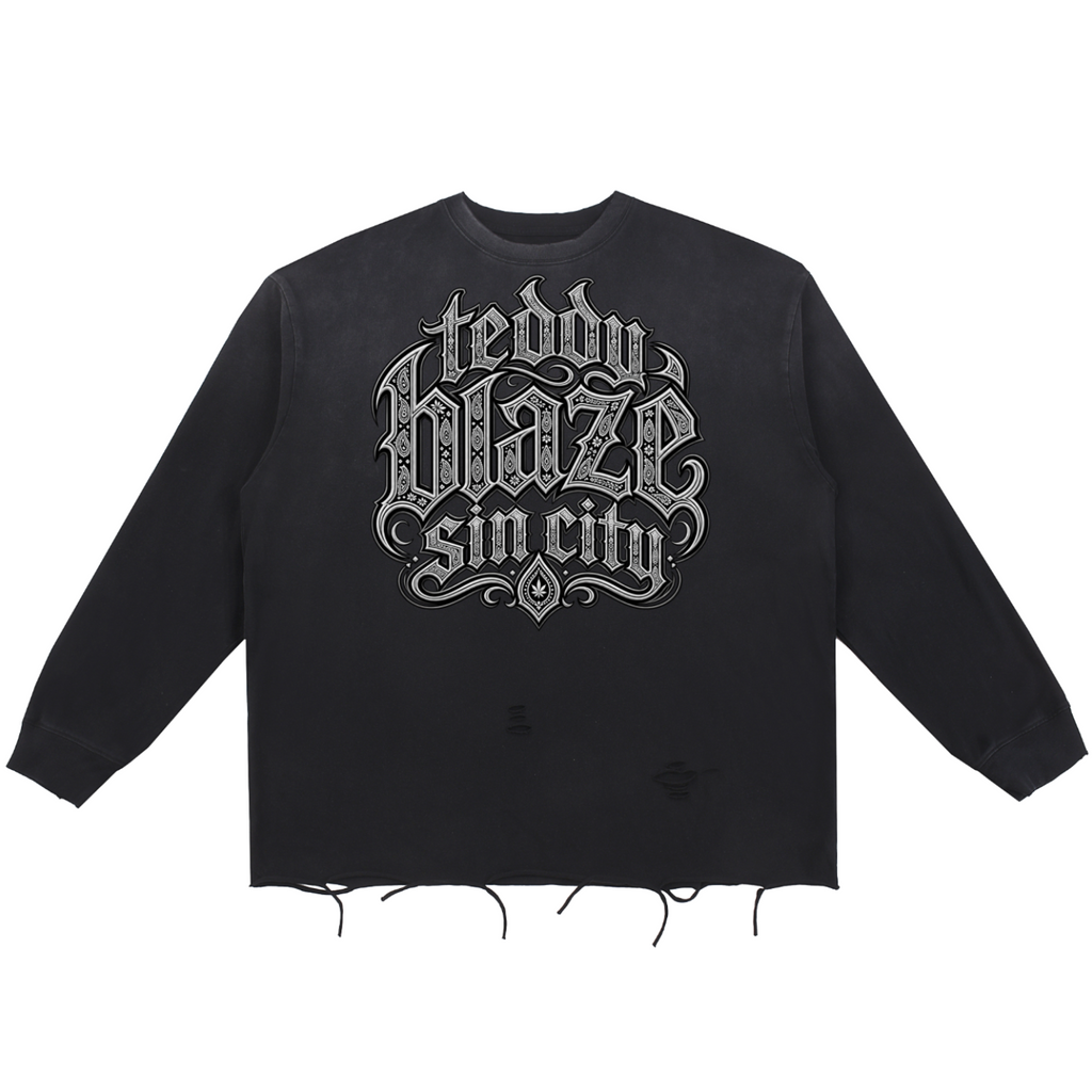 Elevate your distressed layers with the Teddy Blaze Sin City Snow Wash Raw Edge Cotton Jumper. Charcoal snow-washed cotton, raw frayed hem, and tattoo praying hands back print. Shop NYC to Vegas style.