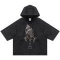 Elevate your casualwear with the Teddy Blaze Sin City Snow Washed Hooded Box Cut Tee. Charcoal snow-washed cotton blend, short raglan sleeves, hood, and tattoo praying hands graphic. Shop NYC to Vegas style.