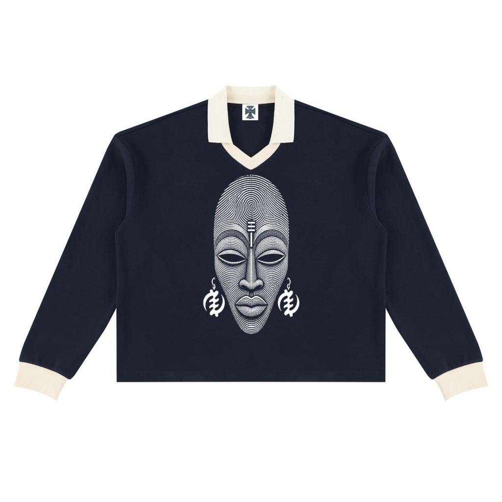 A navy blue long-sleeve rugby-style sweater with cream ribbed collar, cuffs, and hem, featuring a large white graphic print of an African mask on the chest.