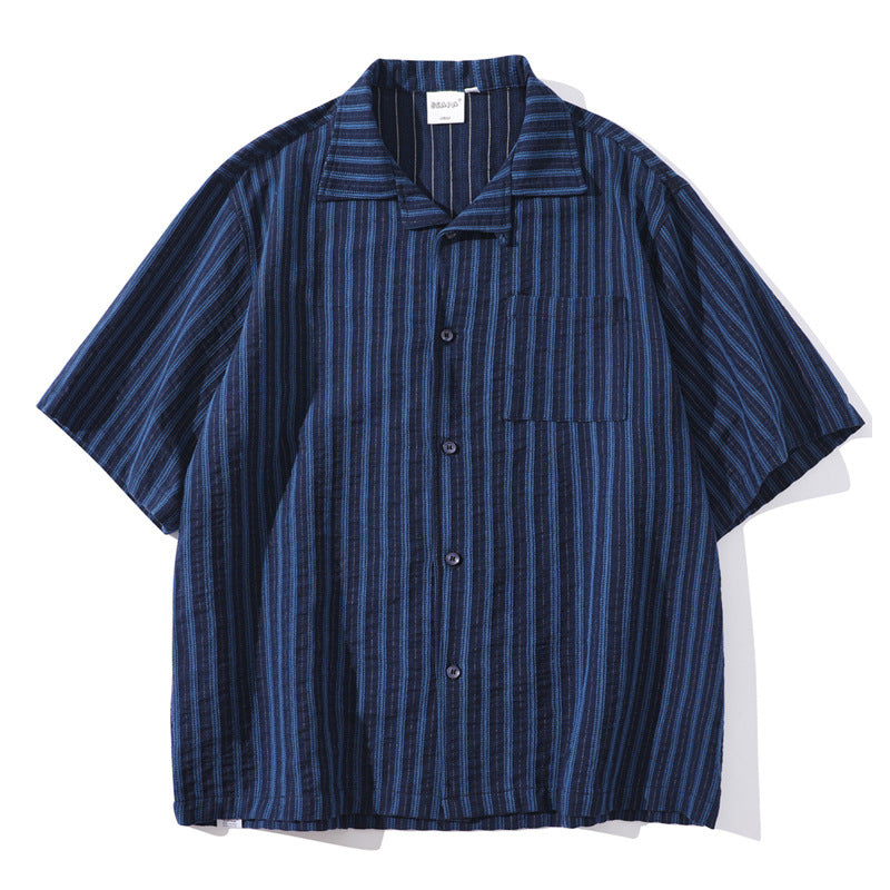 Shop the Teddy Blaze Indigo Scholar Stripe Camp Shirt, a relaxed 100% cotton short-sleeve shirt with indigo vertical stripes, camp collar and easy oversized fit.