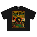 A black short-sleeve t-shirt with a large, colorful graphic print on the front. The graphic features the text 'VOTING IS POWER' in a yellow and red neon-style font, surrounded by images of civil rights figures and slogans including 'POWER TO THE PEOPLE' and 'TEDDY BLAZE'.